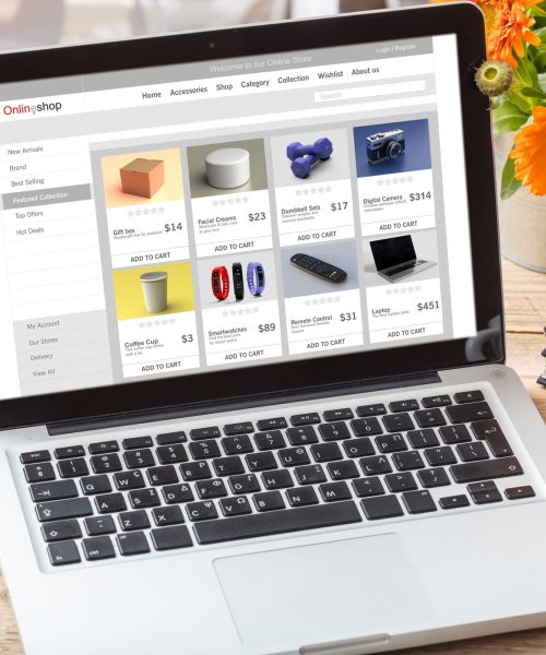 Online shop website design template on a laptop monitor, office desk background.